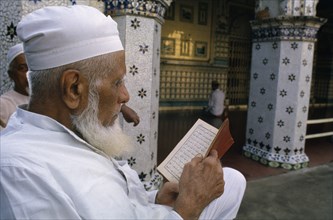 BANGLADESH, Dhaka, Man reading the Koran.