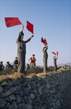 NORTH KOREA, North Hwanghae Province, Pyongsan County, Juche people waving red flags cheering