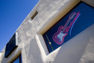 USA, New Mexico, Santa Fe, Illuminated Budweiser sign and electric guitar in window of Blues Club