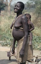 ETHIOPIA, West, Gambella, Uduk refugees from Sudan.  Smiling pregnant woman carrying baby on her