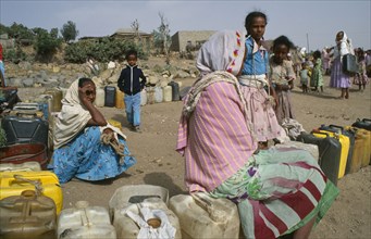 ERITREA, Seraye, Women and children waiting at water point in provincial town.