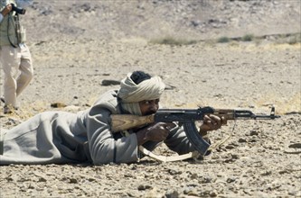 WESTERN SAHARA, SADR, Polisario Front soldier firing kalashnikov.  The Polisario Front is a Sahrawi