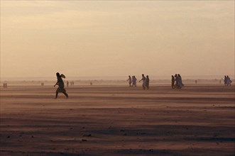 WESTERN SAHARA, SADR, People moving across desert landscape.