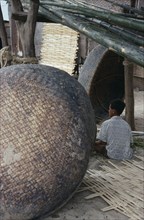 VIETNAM, Nha Trang, Boat building. Boy sat under bamboo