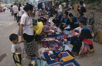 LAOS, Luang Prabang, Hmong market vendors with colourful textile stalls