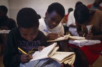 MOZAMBIQUE, Espungabera, Schoolchildren writing in exercise books.