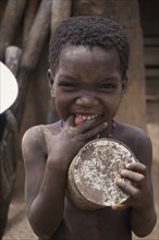 GHANA, North, People, Portrait of small child pulling face with fingers in mouth.