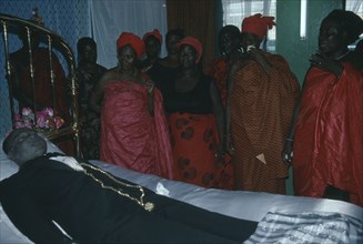 GHANA, Accra, Funeral of man from the Ga community.  His wife talks to her dead husband as is