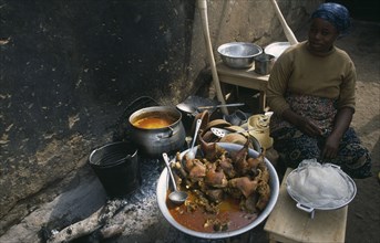 GHANA, Central, Food, Woman selling stew of guinea-fowl at street food stall.