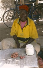 GHANA, Markets, Man selling palm nuts.