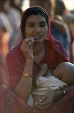 INDIA, Uttar Pradesh, Varanasi, Young mother breastfeeding baby.