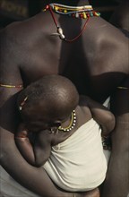 SENEGAL, South, Cropped shot of Bassari mother carrying child on her back.
