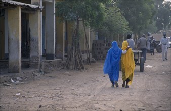 ERITREA, Tessanie, Two women with one woman resting her hand on others shoulder walking along road