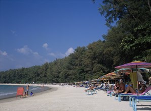 THAILAND, North Phuket, Naiyang Beach, View along the sandy beach with row of sun loungers and