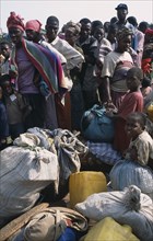 GUINEA, Kissidougou, Camp for Sierra Leonean Refugees. People with sacks moving camp