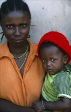 GUINEA BISSAU, Kissidougou, Camp for Sierra Leonean refugees. Portrait of Mother holding child