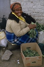LESOTHO, Maseru, Woman at Maseru market selling greens from cardboard box