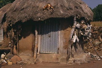 IVORY COAST, Architecture, Village hut with straw roof and fetishes attached to exterior