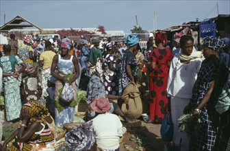 GAMBIA, Banjul, Women at market wearing brightly coloured clothes
