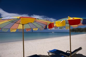 THAILAND, North Phuket, Naiyang Beach, "Two multi coloured parasols and  sun loungers on the sandy