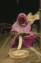 SUDAN, North East, Work, Eritrean woman in Gadum Gafriet refugee camp making birrish matting woven