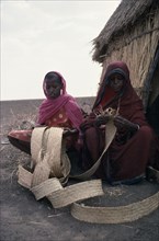 SUDAN, North East, People, Women weaving palm leaves to make baskets.