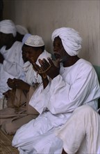 SUDAN, Religion, Dervishes praying holding prayer beads.