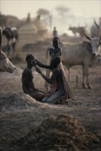 SUDAN, Tribal People, Dinka girls applying facial decoration for wedding celebrations watched by