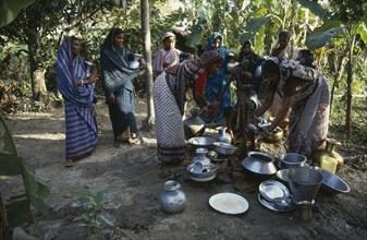 BANGLADESH, Water, Women collecting water at hand pump.