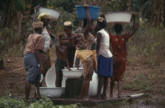 NIGERIA, Mid West State, Women and children collecting water at stand pipe.