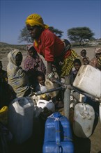 ETHIOPIA, Jijiga, Woman filling water containers at standpipe in Somali camp.