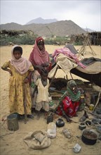 SUDAN, North East, Gadem Gafriet Camp, "Beni Amer nomad refugee women and children outside small,