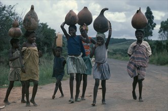 ANGOLA, People, Girls, Group of young girls returning from fetching water and carrying gourds on