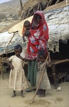 SUDAN, North East, Gadem Gafriet Camp, Beni Amer nomad refugee woman and children outside tent in