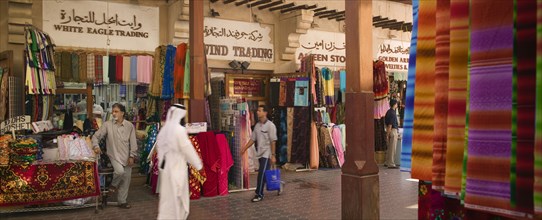 UAE, Dubai, Fabric traders and shoppers in Bur Dubai Souq.