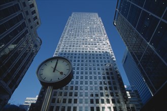 ENGLAND, London, Canary Wharf. View of the tower at 1 Canada Square with clock in the foreground.