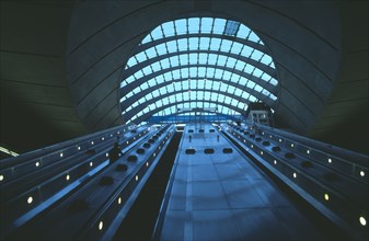 ENGLAND, London, Canary Wharf Underground station escalators and glass roof.