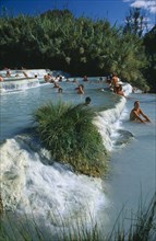 ITALY, Tuscany, Saturnia, Tourists in terraced thermal pools.
