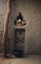 MALI, Housing, Detail of mud brick house near Kayes with bowl and basket in niche in wall and