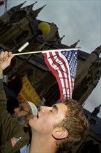 ENGLAND, London, A demonstrator waves a defaced North American flag during an anti Bush rally.
