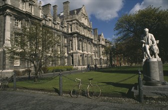 IRELAND, Dublin, Trinity College.  Exterior facade and grounds with chained bicycle and statue of