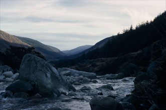 IRELAND, Co. Wicklow, Glenmalure Valley, Wicklow Mountains in winter with rocks in river in the