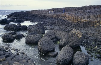NORTHERN IRELAND, County Antrim, Giant’s Causeway, Visitors on rocky promontory of North West Moyle