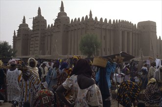 MALI, Sahel, Djenne, Busy market scene with Grand Mosque behind.
