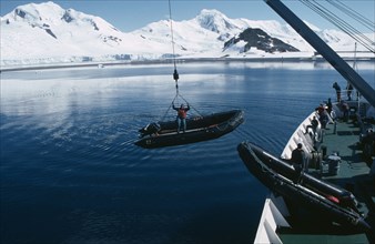 ANTARCTICA, Ships, Lowering Zodiacs for taking passengers ashore. Person standing in the small boat