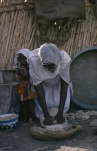 SUDAN, Food and Drink, Woman making bread with young child beside her.