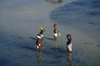 MOZAMBIQUE, Pemba, Elevated view over women wading in the sea carrying bowls and buckets on their