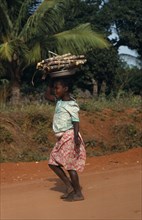 MOZAMBIQUE, Work, Young girl carrying cut lengths of sugar cane on her head.