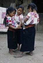 MEXICO, Chiapas, Zinacantan, Three little girls standing together in street.