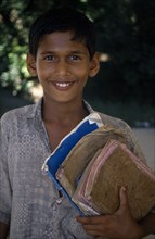 BANGLADESH, Education, Portrait of boy holding school books.